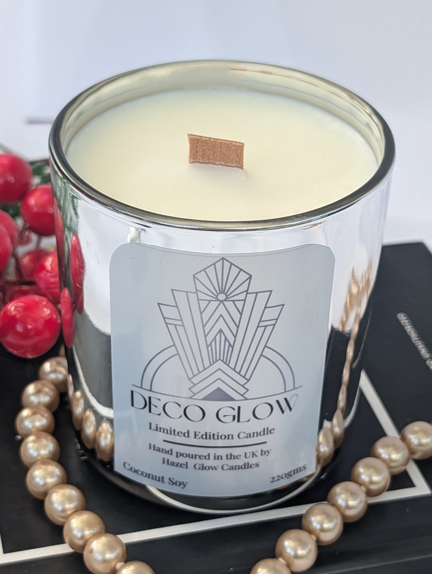 Top view of Deco Glow candle on a book with pearls and berries