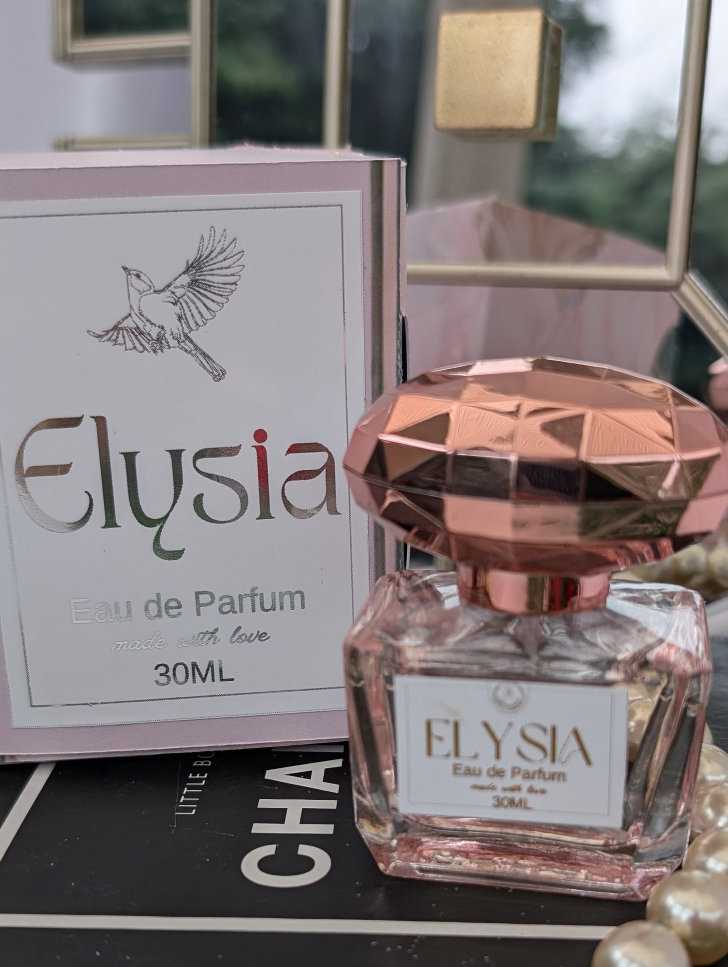 Elysia perfume bottle with packaging on a book with Chanel branding