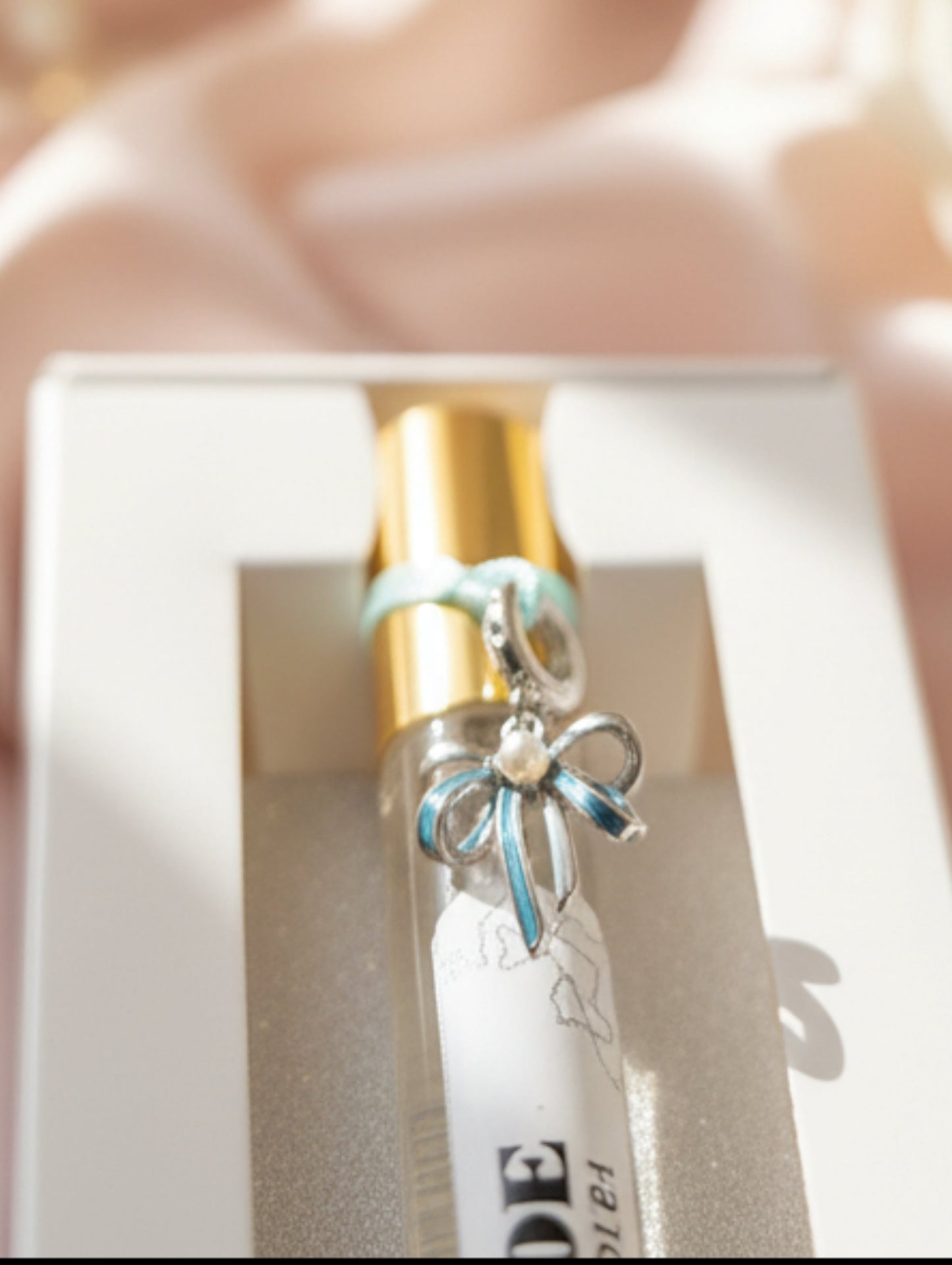 Mother of the Groom Gift, 10ml personalised perfume by Hazel Glow - close up of optional sterling silver bow shaped bracelet charm