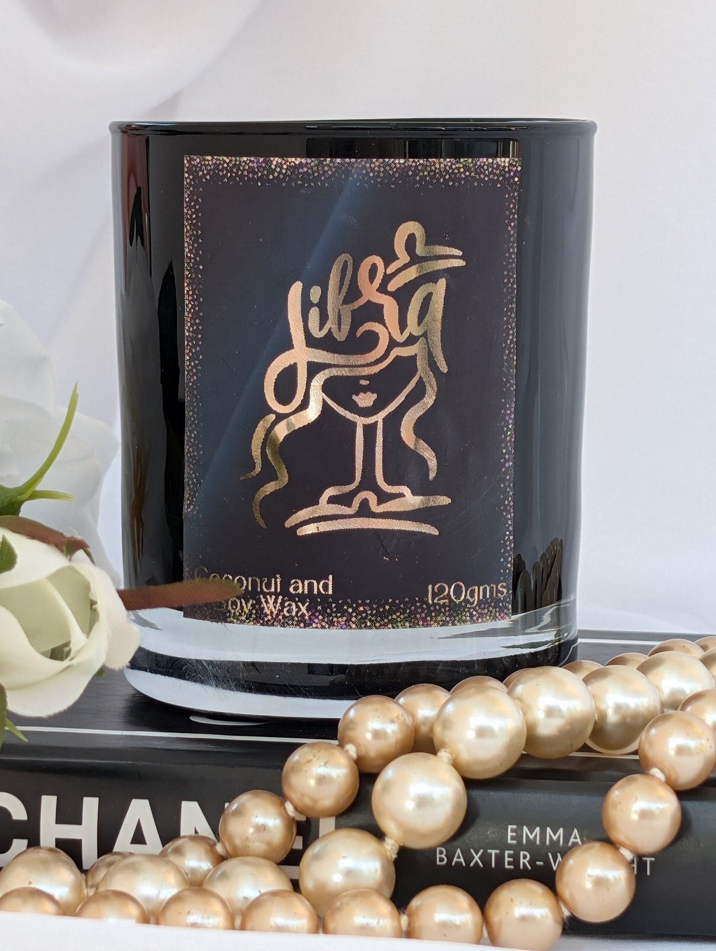Libra Zodiac Black candle with gold design and text, surrounded by pearls and a Chanel book.