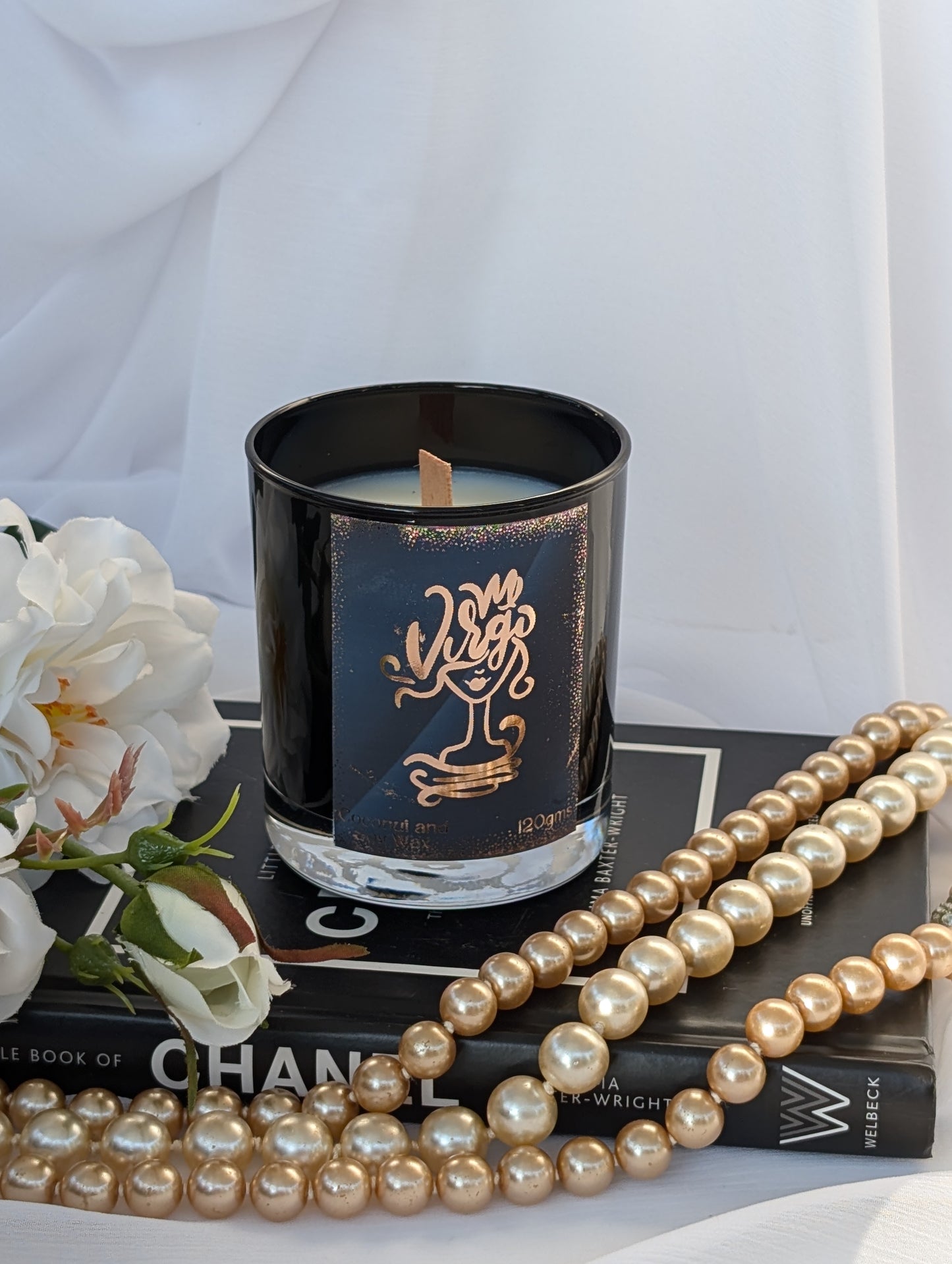 Virgo black and gold star sign candle on black book with pearls and white flower