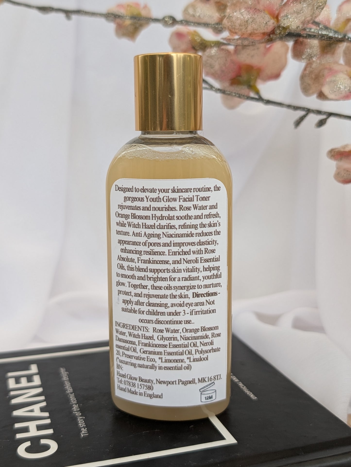 Ingredients label of Youth Glow Facial toner bottle with gold cap and white label on a Chanel magazine background