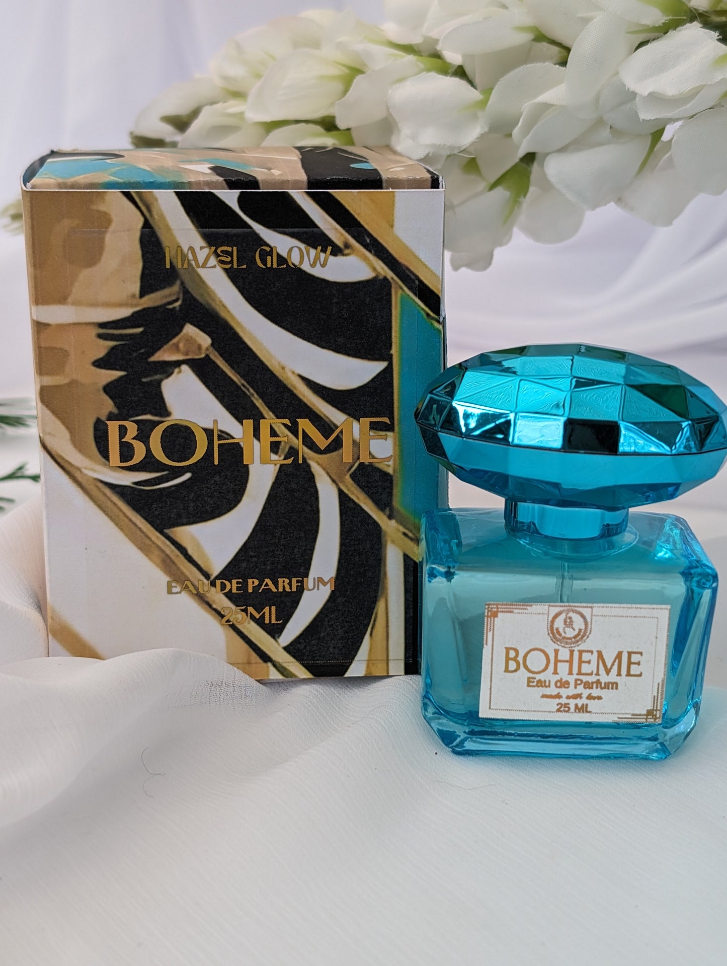 Boheme Gourmand perfume - blue bottle and packaging on a white background with flowers.