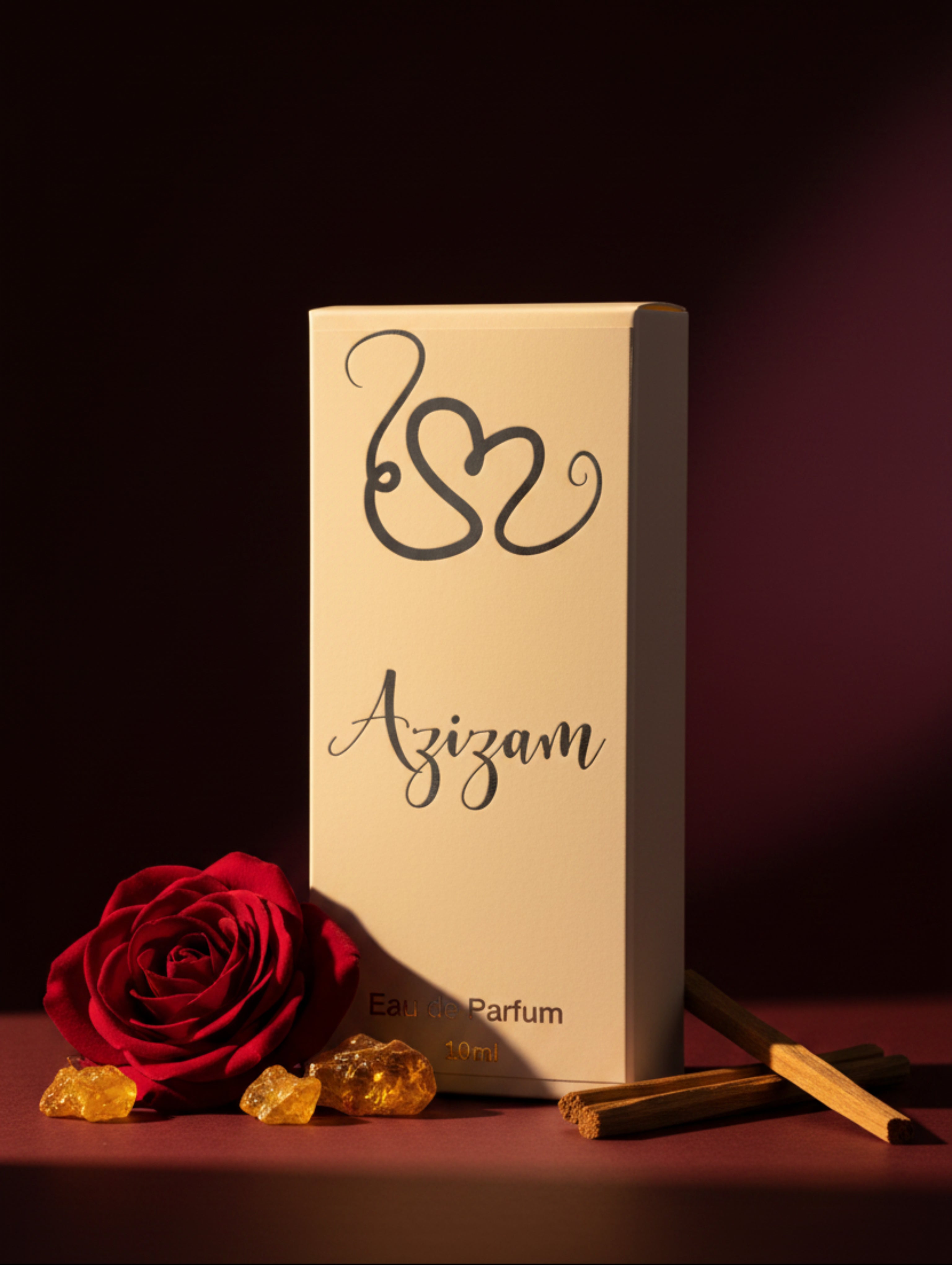 A tall white rectangular box for Azizam Eau de Parfum, featuring a silver heart-shaped monogram and black cursive brand name, displayed on a white pedestal against a beige background.burgundy surface with rose amber and oud