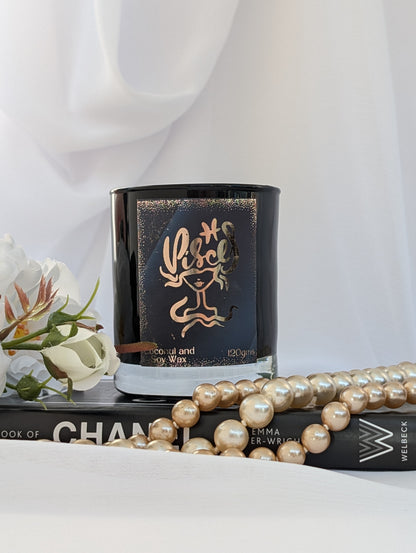 Black and Gold Pisces Candle on black book with pearls and flowers