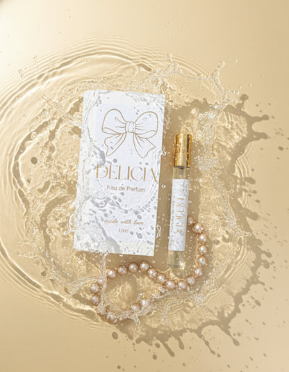 Delicia Eau de Parfum bottle and packaging with a bow design on a blurred background