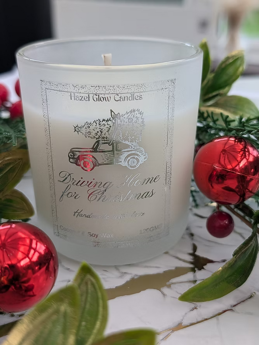 Frosted Christmas Fragranced candle with 'Hazel Glow Candles' branding and Christmas-themed design, surrounded by festive decorations.