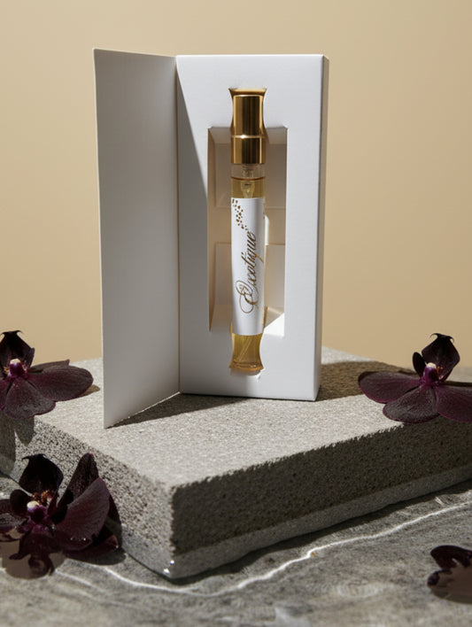 Vegan perfume trial size Exotique by Hazel Glow, on a stone plinth in water with black orchids

