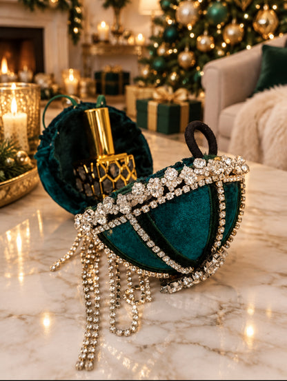 Hand decorated limited edition secret santa bauble shown open on a marble table with gold 10ml perfume inside