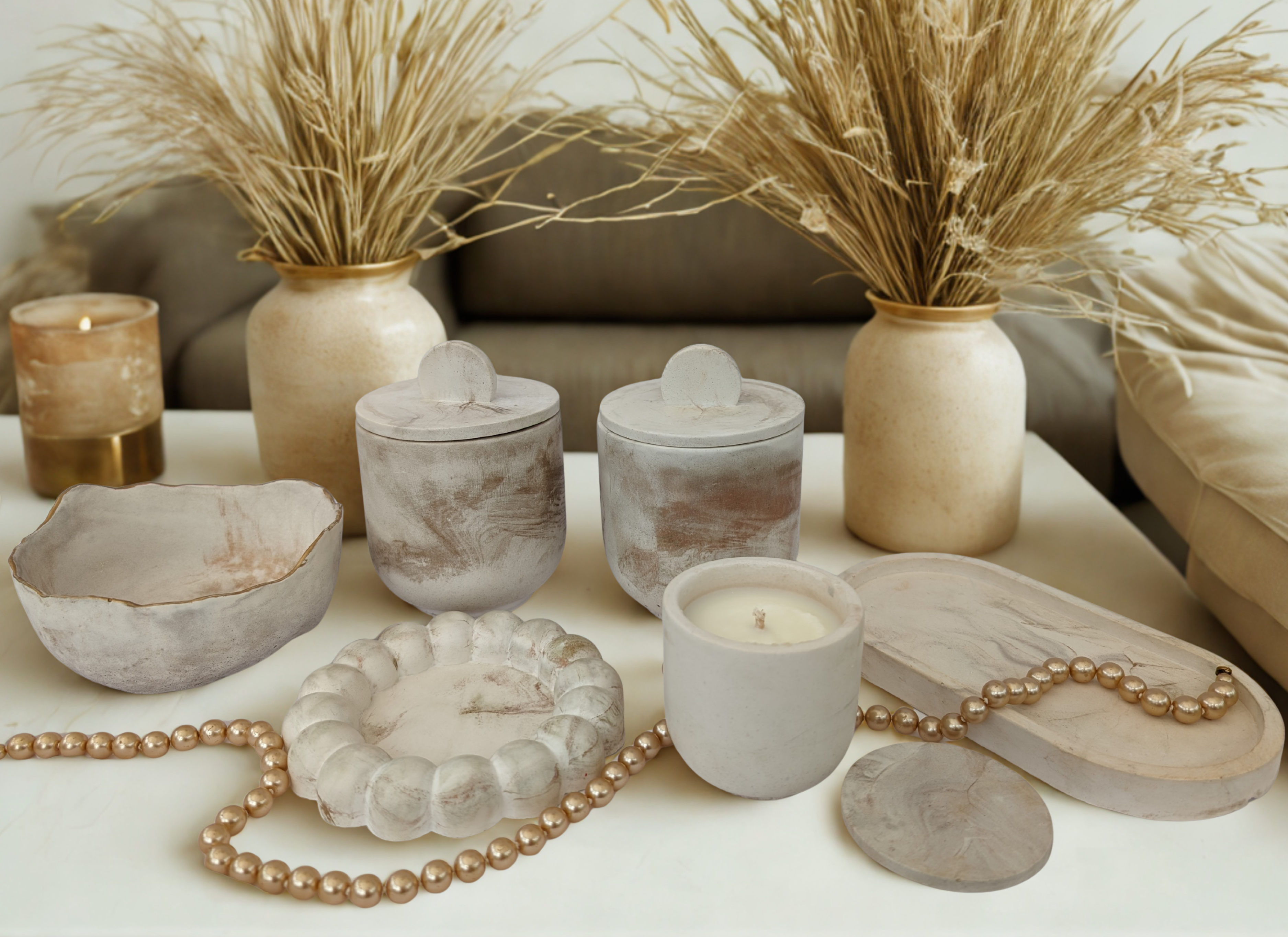Decorative items including candles, vases, and a pearl necklace on a table.