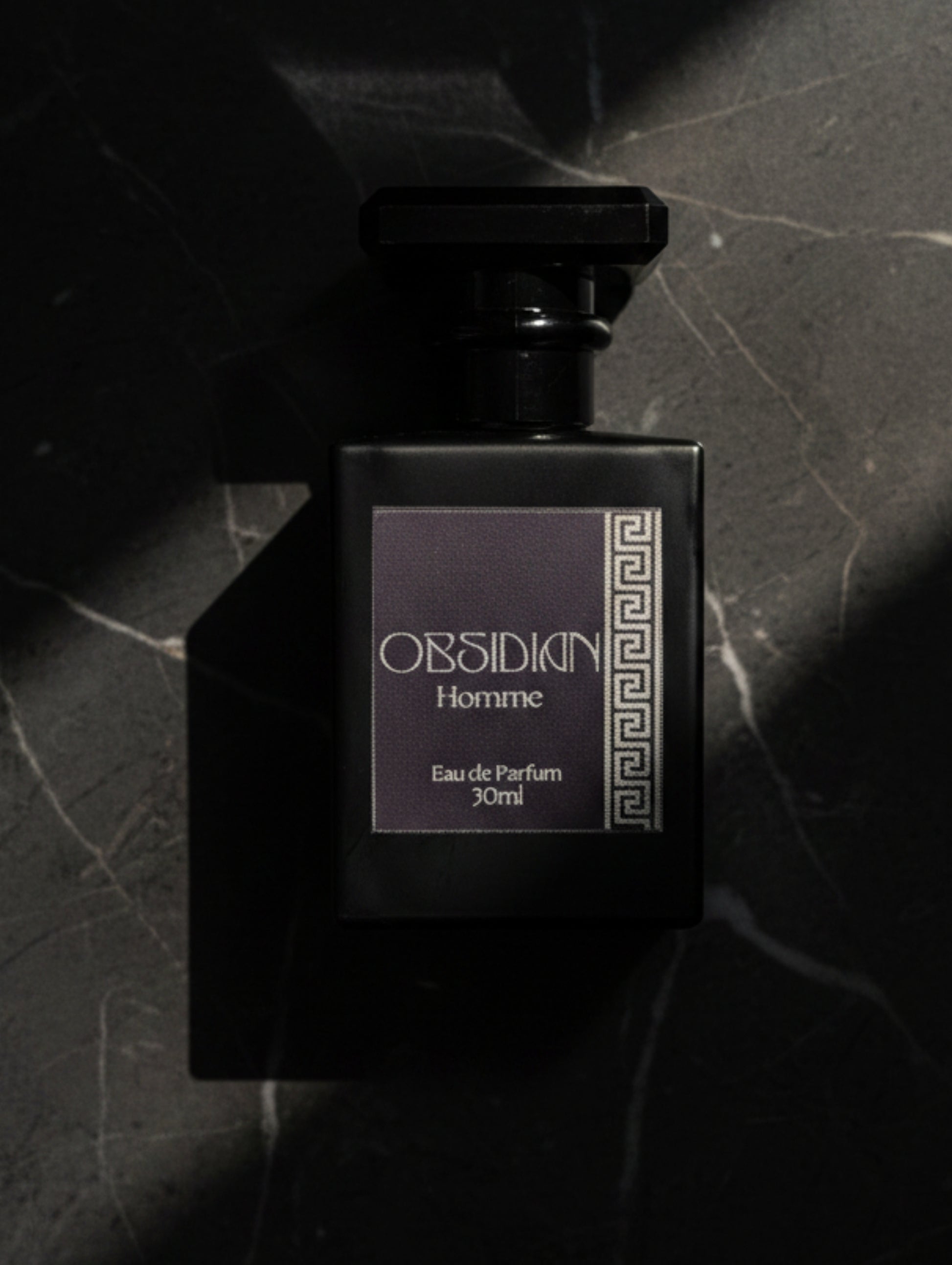 Obsidian Fragrance for Men by Hazel Glow, Black bottle with silver foiled label on black marble