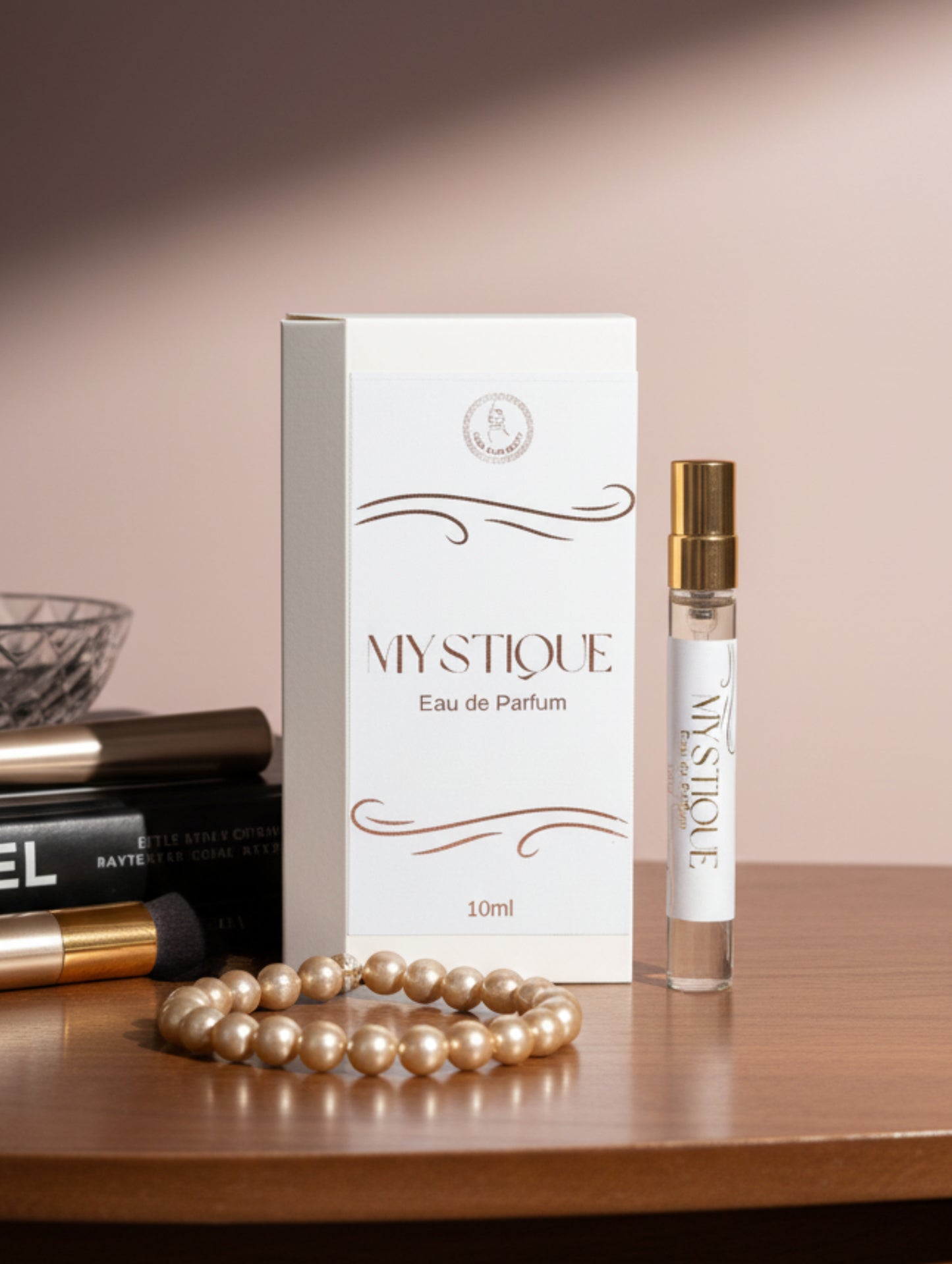 Mystique vegan fragrance by Hazel Glow on a wooden surface with pearls and books