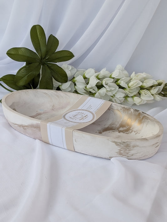 Neutral home decor - marble  effect bowl with a label on a white fabric background with green and white flowers