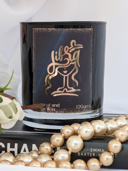 Libra Zodiac Black candle with gold design and text, surrounded by pearls and a Chanel book.