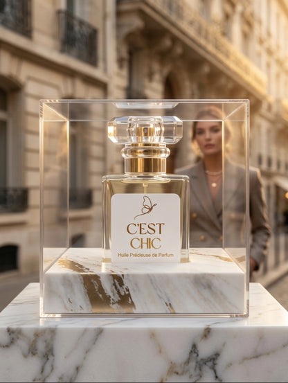 C'est Chic luxury perfumed oil spray in acetate box on marble plinth set against a Parisian street.  Vegan, cruelty free, alcohol free and paraben free perfumed oil