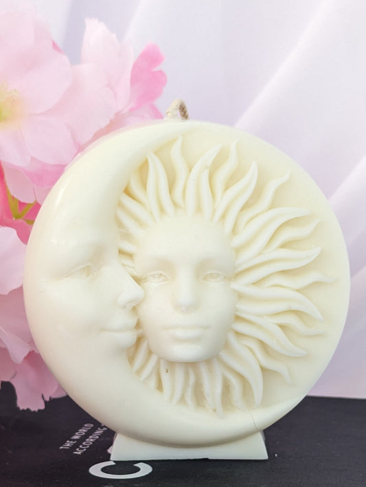 Sun and Moon Vegan Candle on top of a black book with flowers in the background