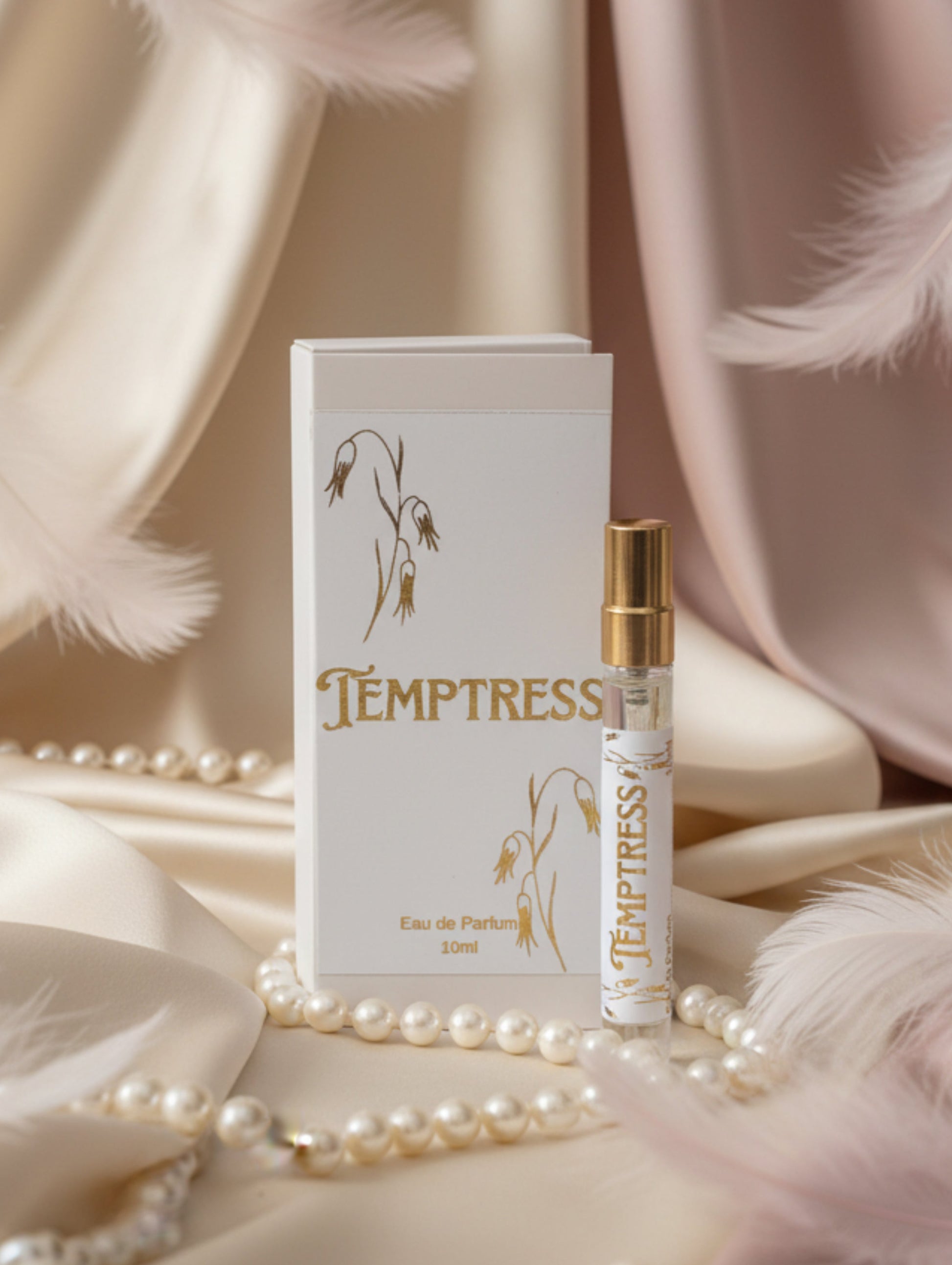 Vegan seductive Temptress eau de parfum 10ml perfume against satin background with pearls and feathers