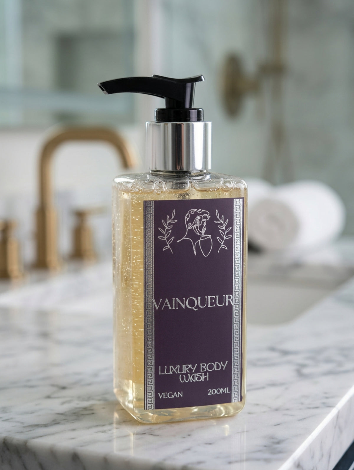 A 200ml bottle of Vainqueur Luxury Shower Ge; with a black pump dispenser and a silver collar, featuring a black and silver foil label, shown in a luxury bathroom