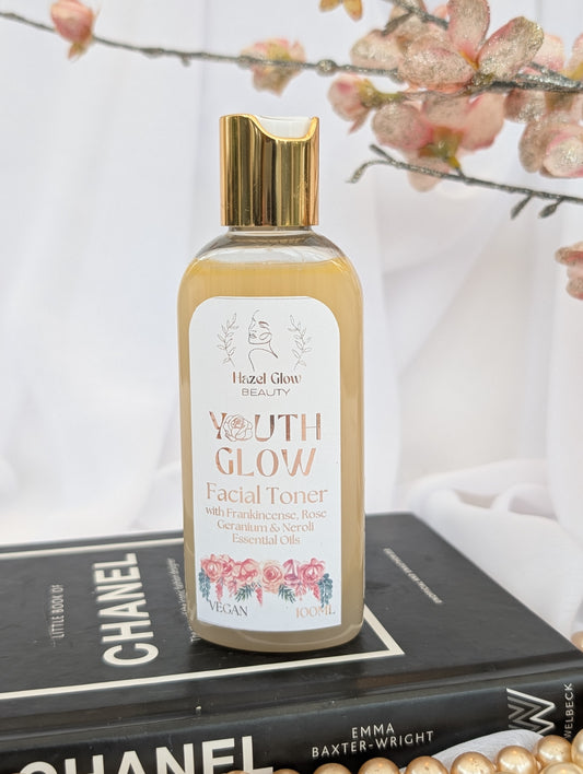 Niacinamide and essential oil  'Youth Glow' facial toner on a book with floral background