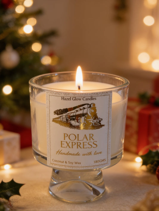 Festive Candle, Coconut wax Polar Express Christmas candle in goblet style clear glass container with gold foil train design on the label.
